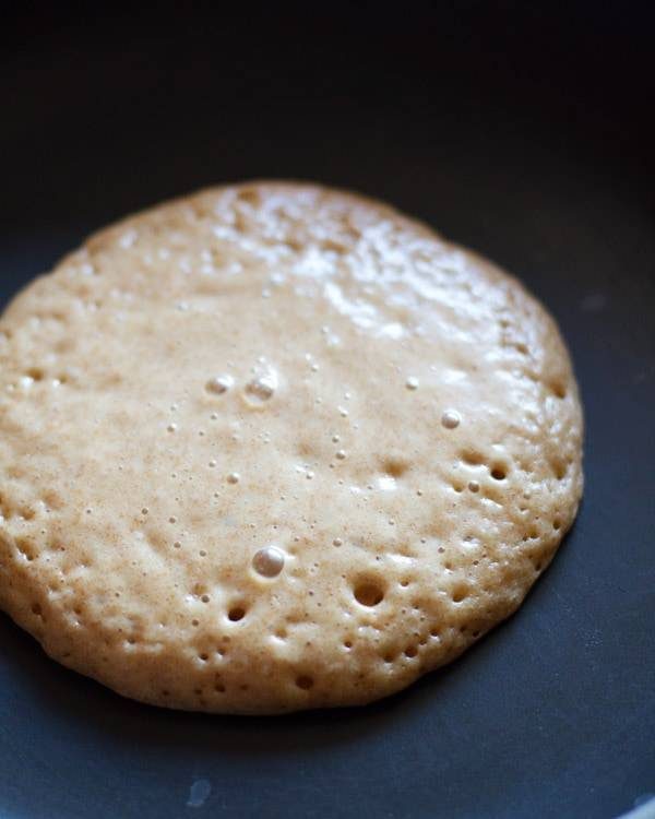 Whole wheat pancake cooking on a skillet.