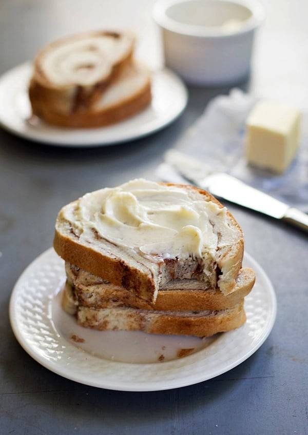 = Cinnamon swirl bread with butter stacked on a plate.