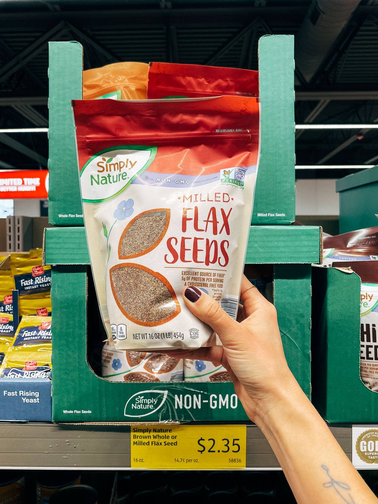 White hand holding a bag of flax seeds