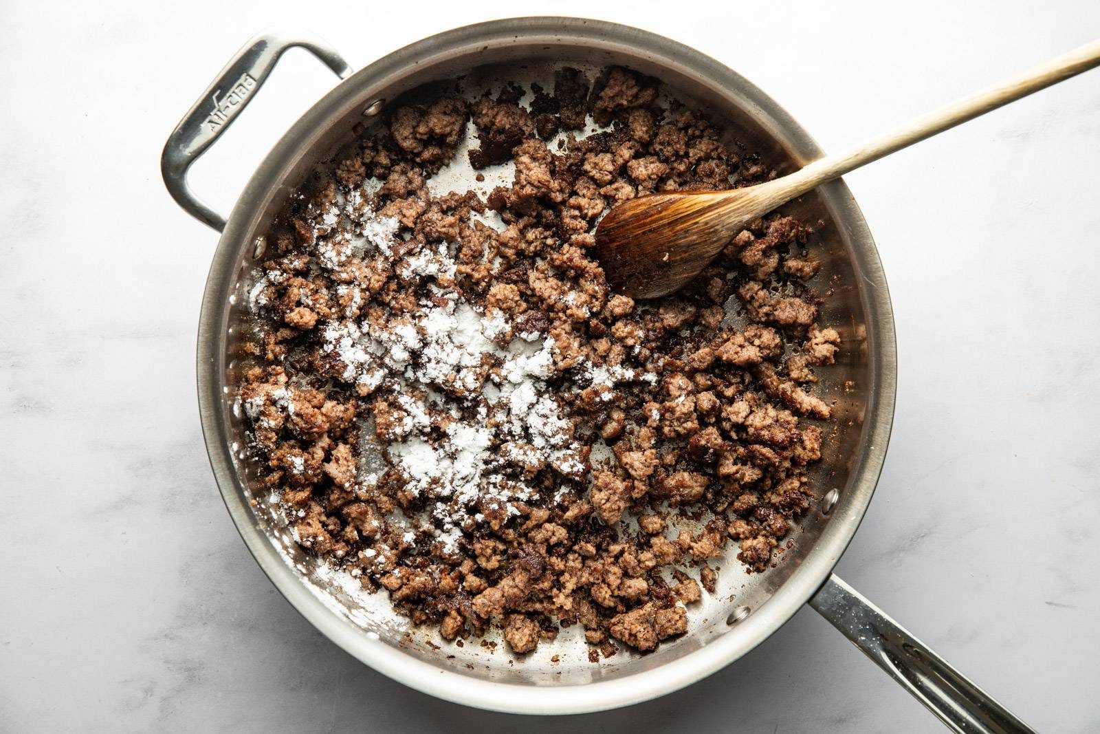 Browning beef in a skillet with cornstarch.