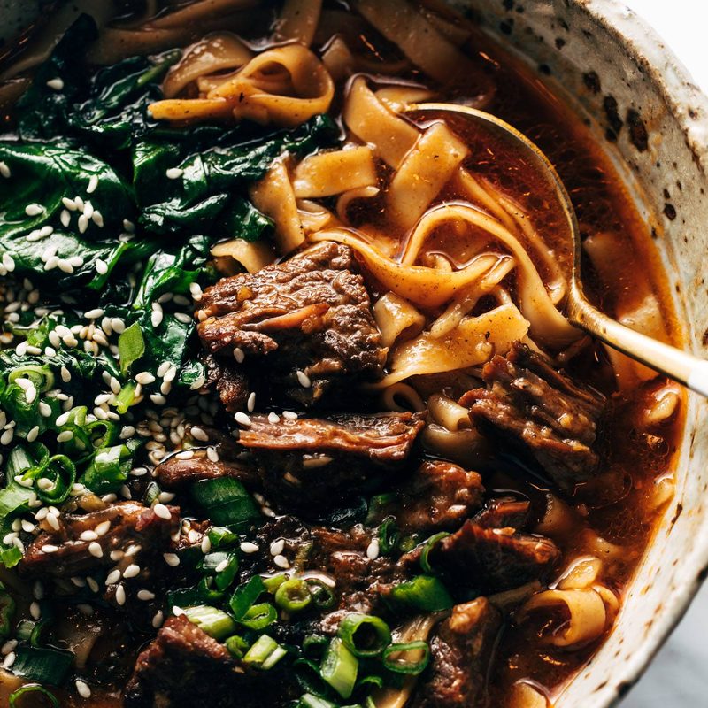 Short rib noodle soup in a bowl with a spoon