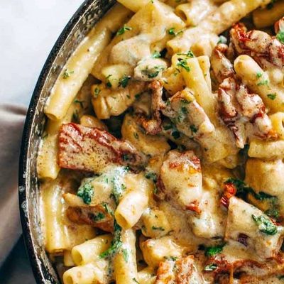Sun Dried Tomato Chicken Florentine Pasta in a pan with a spoon.
