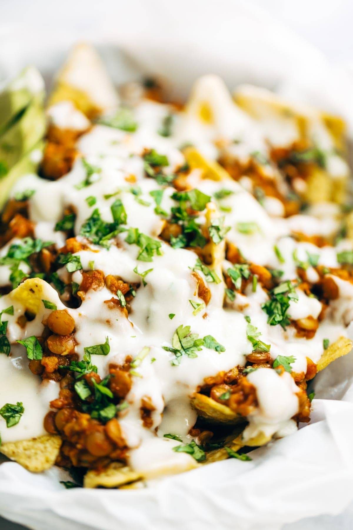 Spicy Lentil Nachos with Three Cheese Sauce - you will not believe how good these are! Saucy filling with a velvety homemade cheese sauce. Vegetarian. | pinchofyum.com