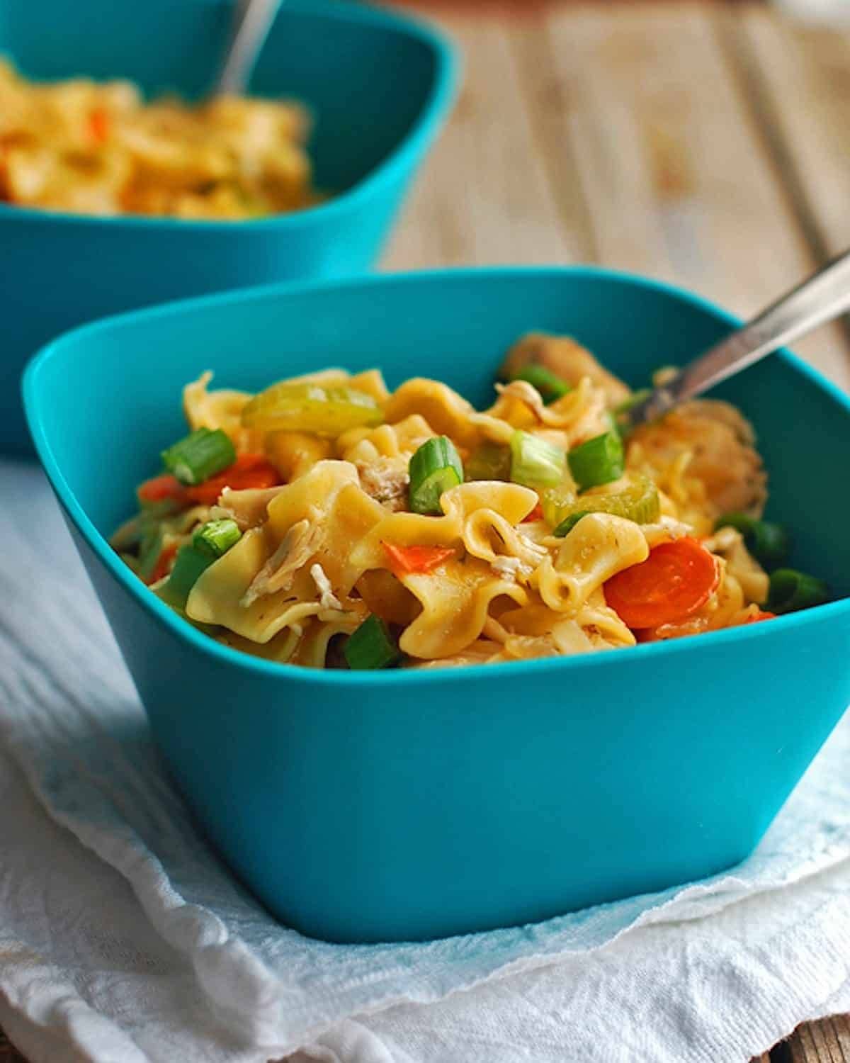 Chicken soup noodles in a blue bowl.